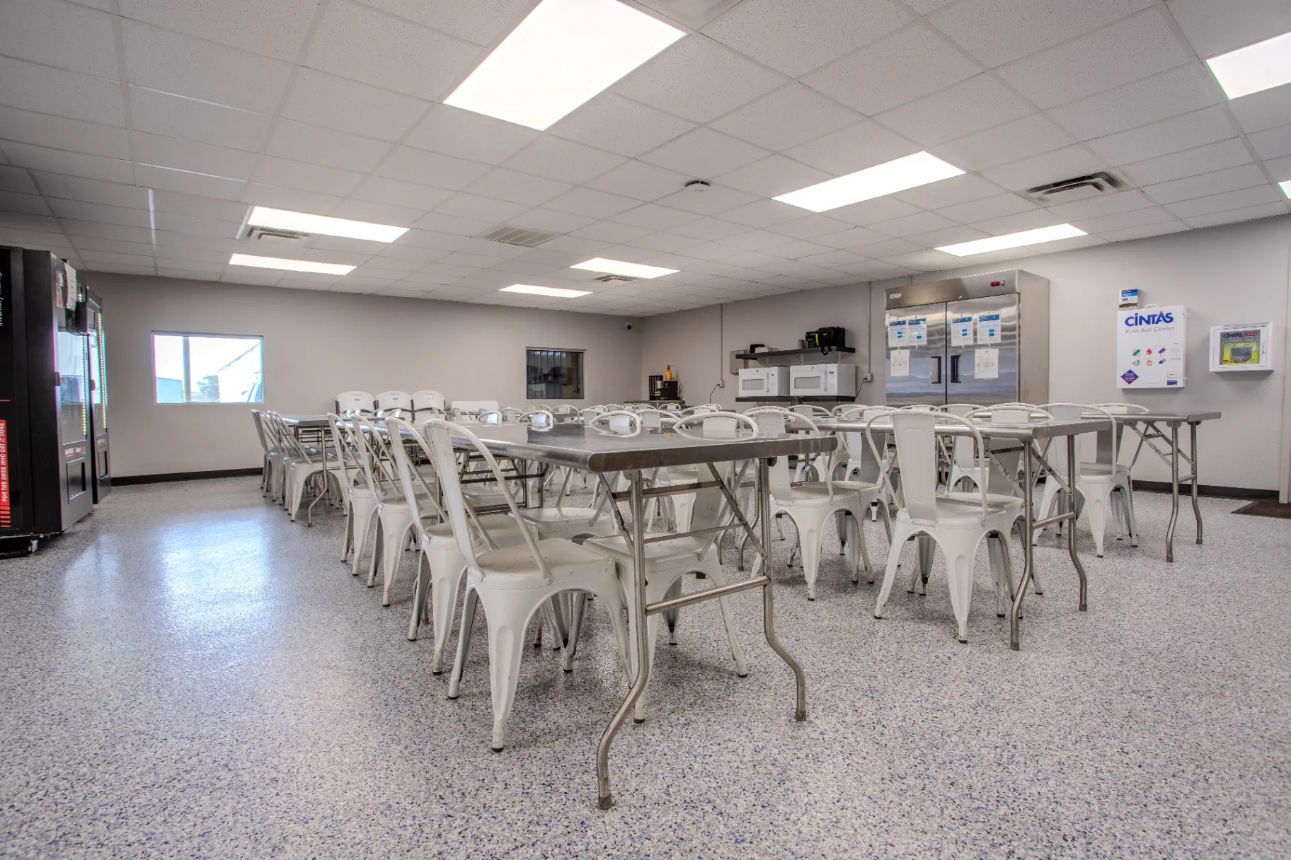 Breakroom amenity wall with commercial refrigeration, microwaves, coffee station, and first-aid center after the conversion