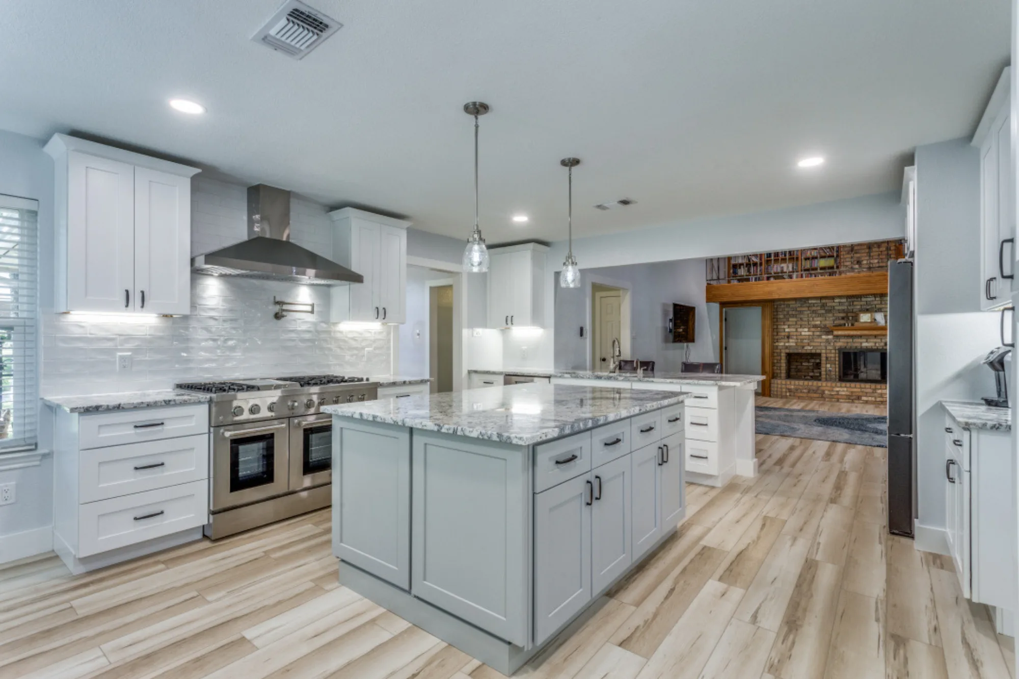 Stainless steel professional gas range and vent hood with white subway tile backsplash